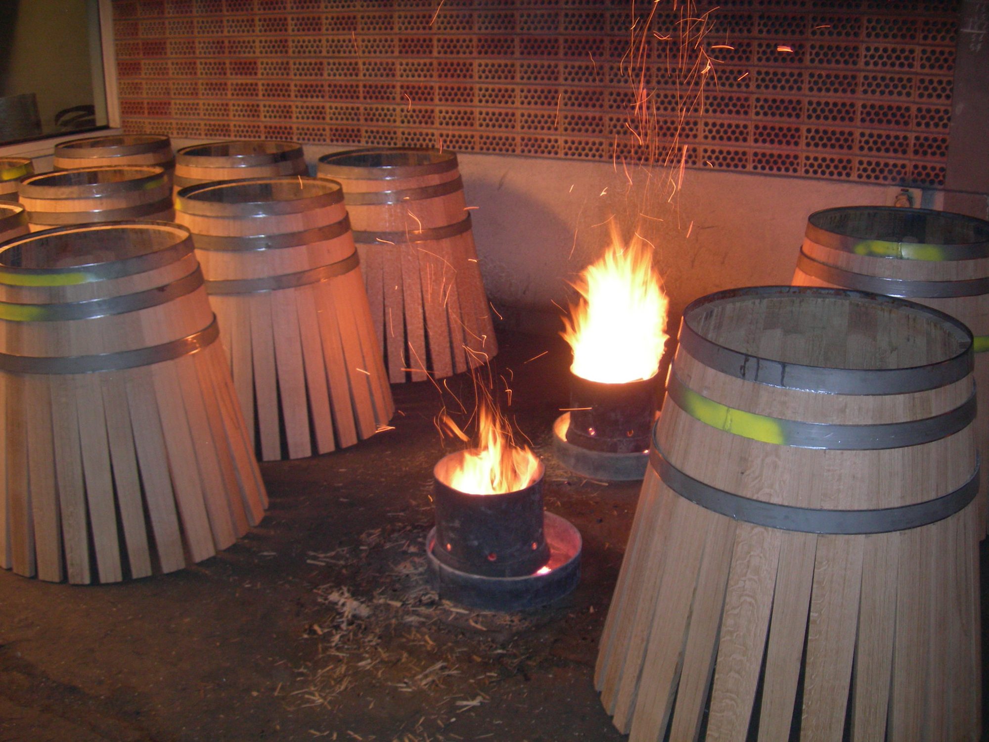 Open fires toasting the insides of new oak barrels at the cooperage