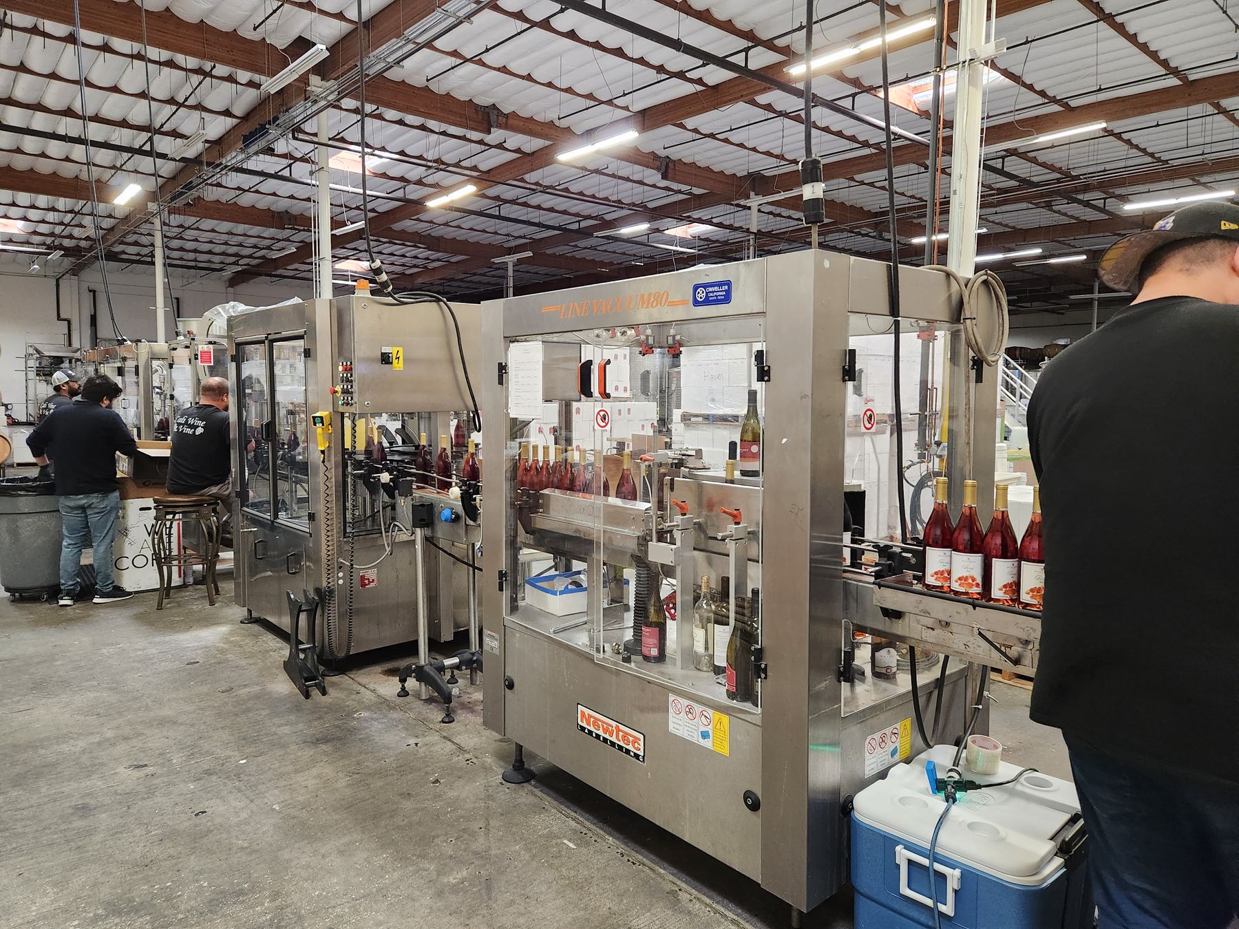 Bottles of Monarey Rosé moving along the bottling and labelling line